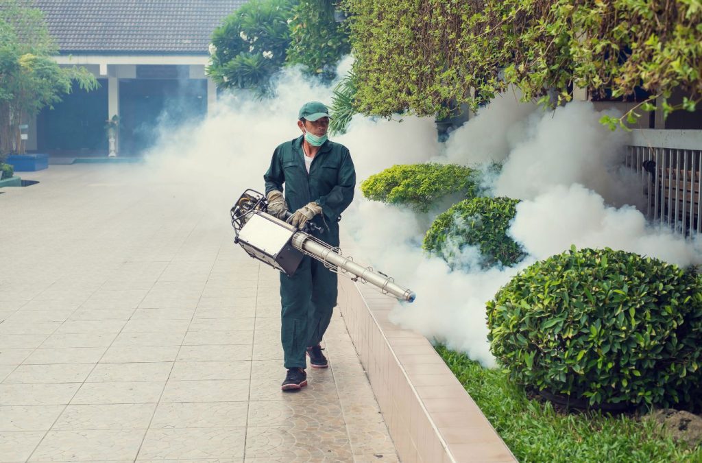 Technician spraying eco-friendly mosquito repellent in a backyard in Bonita Springs, FL.