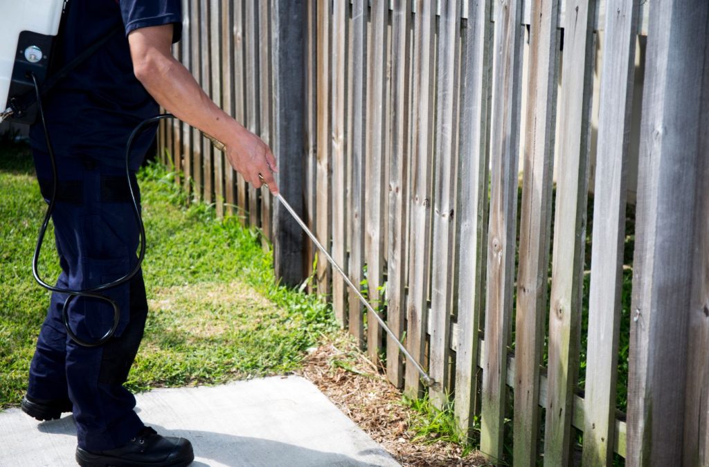 Technician applying termite control treatments to protect a home in Bonita Springs, FL.